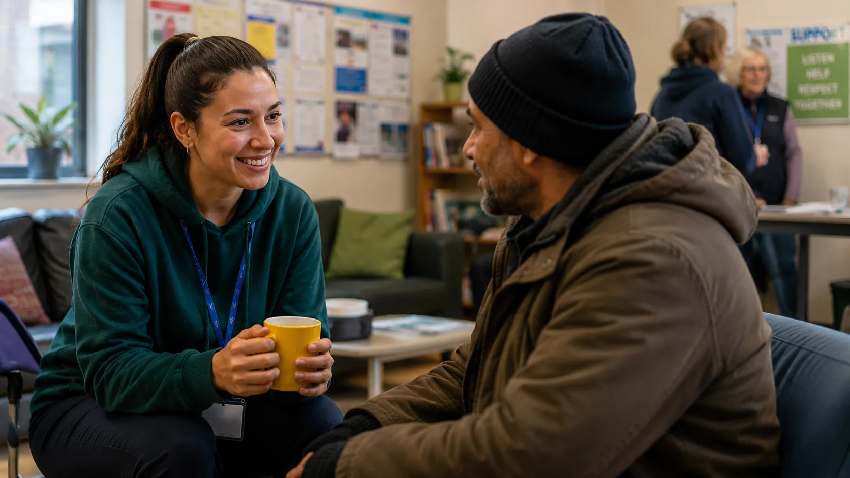 A woman speaking with an older man in a community room